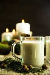 hot milk alcoholic drink   Egg-nog next to the Christmas candle and candles