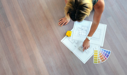 Young woman looking house plans on the floor