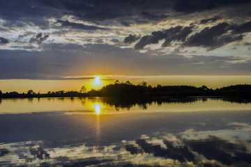 Fototapeta na wymiar Clouds over the lake at sunset