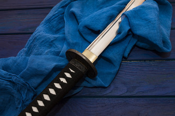 japan katana sword on the wood background with the blue shawl