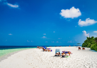 Fototapeta na wymiar Tropical island vacation image, white sand beach and sun beds