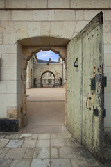 Porte de la prison de l'abbaye de Fontevraud donnant sur la cour intérieure du monastère gothique.