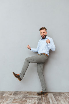 Full-length image of happy screaming bearded man in business clothes