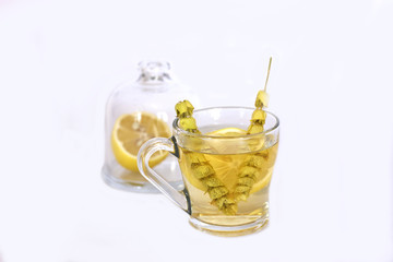 Hot tea with sage and lemon in a glass mug.