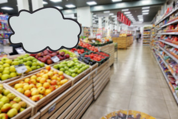Supermarket store. Shelves with food and fruits. Defocused image. Place for your text or advertisement.