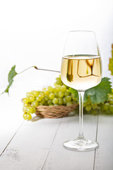 Glass of white wine on vintage white  table