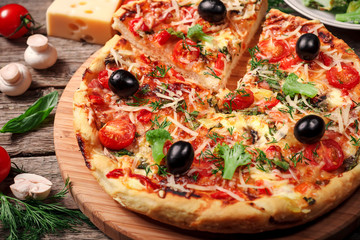 Fresh pizza with tomatoes, cheese and mushrooms on wooden table closeup