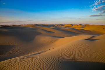 Fototapeta na wymiar Natural beautiful desert landscape, sand dunes on blue evening sky background