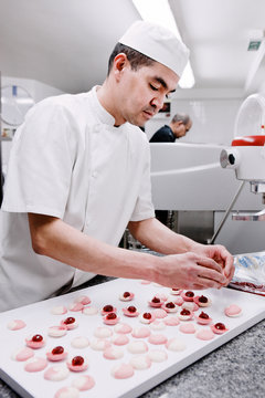 p&acirc;tissier pr&eacute;pare des macarons