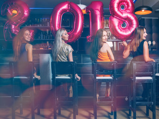 Fototapeta na wymiar New Year females party at bar. Unrecognizable women group, friends celebration. Club background, festive mood