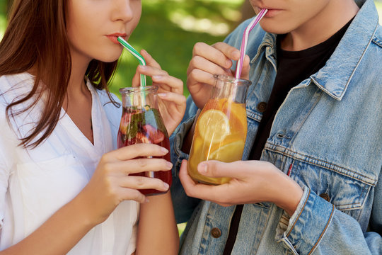 Healthy nutrition. Unrecognizable couple drinking fresh juice detox tea. Young friends lifestyle, vegetarian diet, fitness food on the go, weight loss together concept