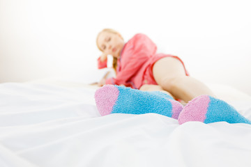 Woman in pajamas wearing furry warm socks