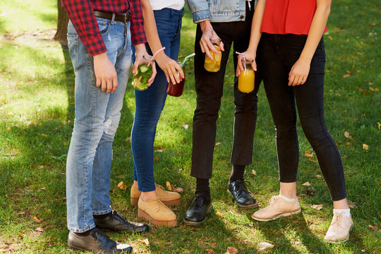 Group of happy young people enjoys detox cocktails and spend time together at summer. Friendship, youth lifestyle, vegetarian diet, fitness food on the go, successful weight loss concept