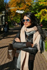 Fototapeta premium Portrait of beautiful young woman in autumn garden. 