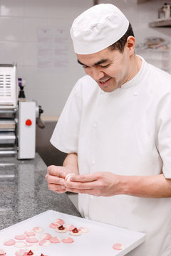 p&acirc;tissier pr&eacute;pare des macarons