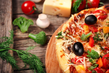 Fresh pizza with tomatoes, cheese and mushrooms on wooden table closeup