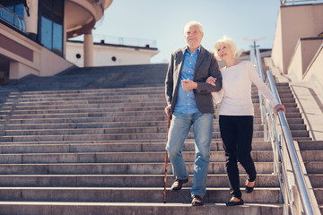 Happy elderly couple going down the stairs