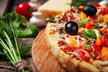 Fresh pizza with tomatoes, cheese and mushrooms on wooden table closeup