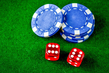 poker chips and dice on green background top view
