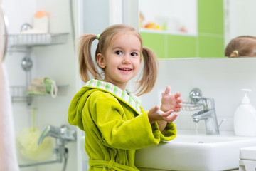 Child girl is showing soapy hands