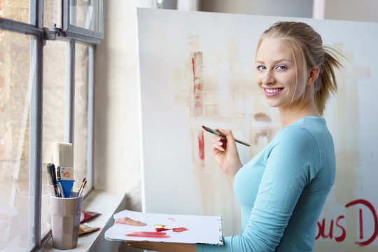 junge künstlerin malt in ihrem atelier