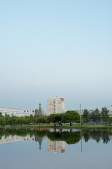 Modern buildings and a wooden church are reflected in the water