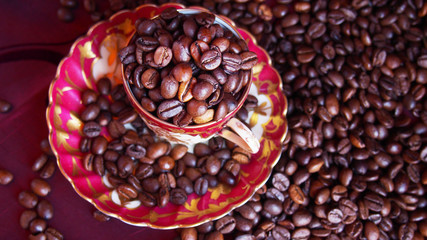 Ziarna kawy w filiżance na czerwonym tle