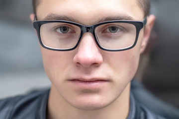 Fototapeta premium portrait of a young serious guy nerd in eyeglasses