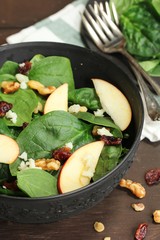 Spinach Apple salad served in a black bowl, selective focus