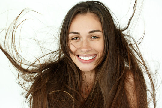 Beautiful woman shakes her hair on white background