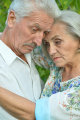 Sad senior couple in  park