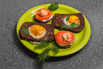 Breakfast -  toast with processed cheese tomato, fried eggs , fried eggs,  on a gray  background.