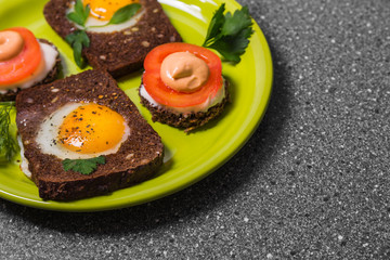 Breakfast -  toast with processed cheese tomato, fried eggs , fried eggs,  on a gray  background.