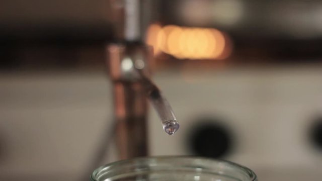 Alcohol distillation equipment, hooch fluid flow into glass jar