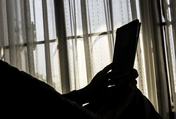 relax man using tablet in the room in silhouette style