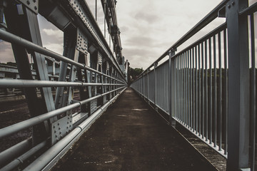 a architecture shot of a bridge walkway with railings each side .