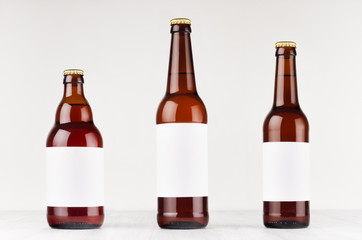 Brown beer bottles collection different type with blank white label on white wooden board, mock up....