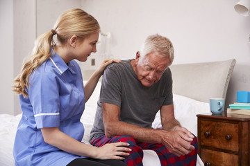 Nurse Making Home Visit To Senior Man Suffering With Depression
