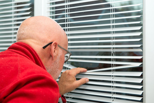 Mature Man Looking Out The Window