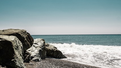 Felsen an Strand und Ozean mit Wellengang