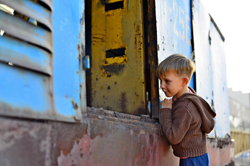 A little boy looks into the void of an iron mechanism