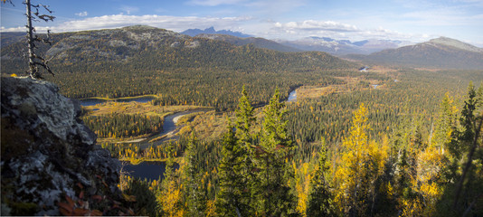 Ural autumn landscape - snow-capped peaks, mountain forests, yellow foliage, transparent cold rivers