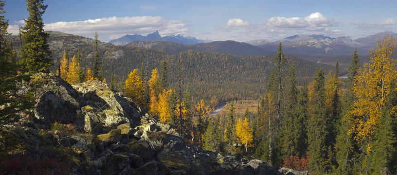 Ural autumn landscape - snow-capped peaks, mountain forests, yellow foliage, transparent cold rivers