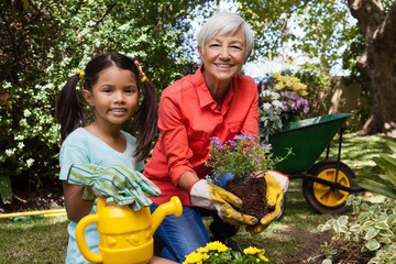 Portrait of smiling girl and grandmother gardening