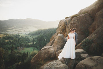 Beautiful wedding couple, bride and groom, in love on the background of mountains