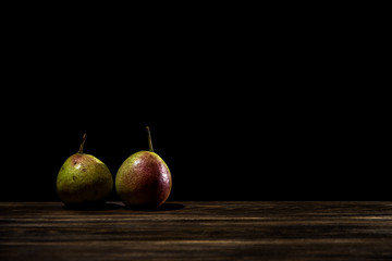 Wild pears isolated on wooden table and dark background.