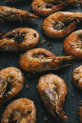 Shrimps on black background. Delicious seafood appetizer served boiled or grilled with spices. Close up. Top view
