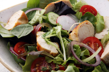 Chicken salad with leaf vegetables and cherry tomatoes.
