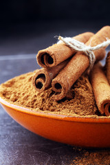 Ground cinnamon, cinnamon sticks, tied with jute rope and cinnamon powder in rustic style.