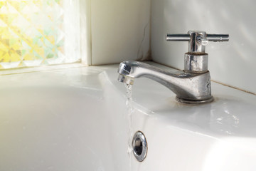 Metal tap with turn on water flow at public rest room. Cleanning concept.